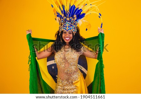 Brazilian afro woman posing in samba costume over yellow background with free space and brazilian flag
