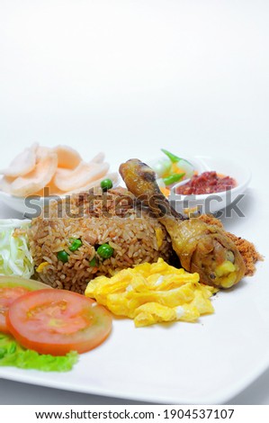 Partially blurred background picture of traditional asian fried rice combined with fried chicken and sliced of omelete 