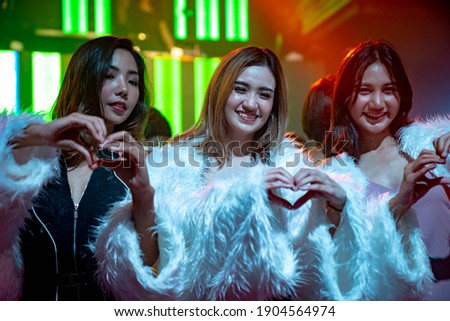 Group of women friend having fun at party in dancing club at night . Social gathering event and nightlife entertainment concept .