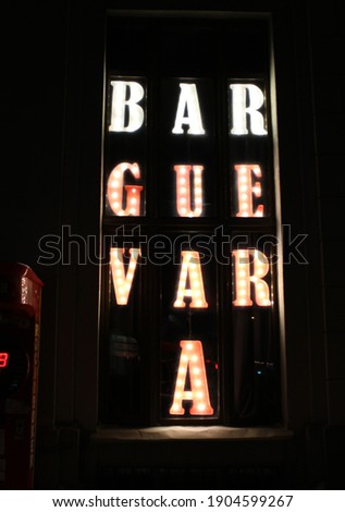 Alphabet letters in vintage style with glowing bulbs inside. Backlit marquee letters illuminated marquee letters name of the bar.