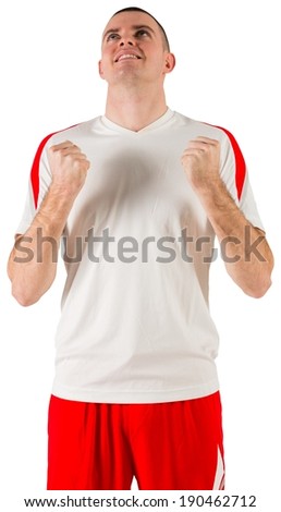 Excited football player cheering on white background