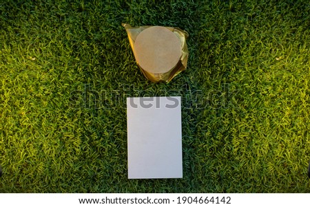 Background of green grass with a card and a handmade gift