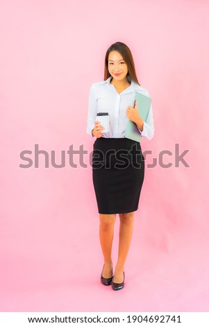 Portrait beautiful young asian woman with computer laptop on pink color background