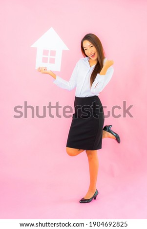 Portrait beautiful young asian woman show house or home sign on pink color background