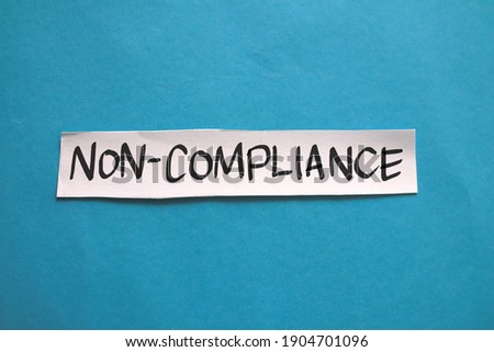 Non compliance, text words typography written on paper against blue background, life and business motivational inspirational concept
