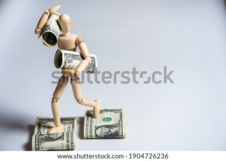 Business concept photo. Wooden man with money. Earnings and salary