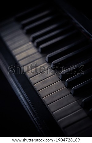 Close up shot of an old piano keyboard, with shallow depth of field.
