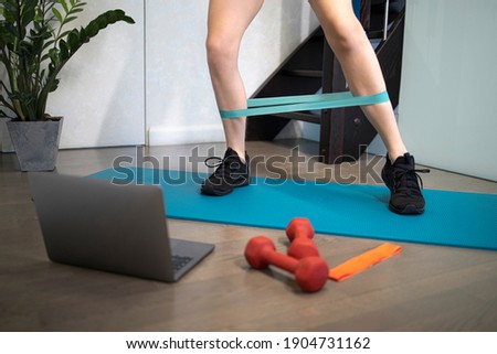 Young sporty slim woman has internet video online fitness training instructor modern laptop screen. Healthy lifestyle concept, online fitness and sport lessons. Exercises at home. Royalty-Free Stock Photo #1904731162