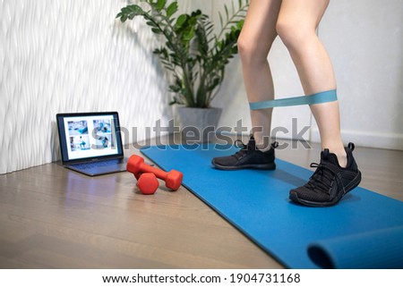 Young sporty slim woman has internet video online fitness training instructor modern laptop screen. Healthy lifestyle concept, online fitness and sport lessons. Exercises at home. Royalty-Free Stock Photo #1904731168