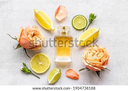 Bottle of perfume with citrus and flowers, top view
