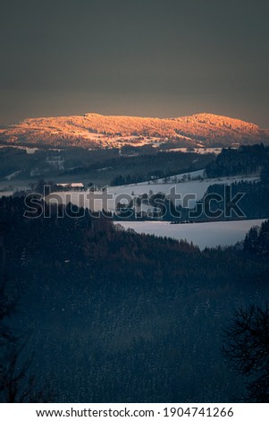 Foggy landscape with mountains illuminated by the sun