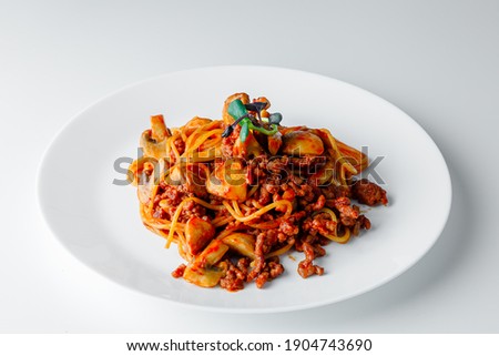 Italian Delicious spaghetti pasta with tomato sauce, parmesan and champignon mushrooms. Bolognese served in a white plate on dark background.