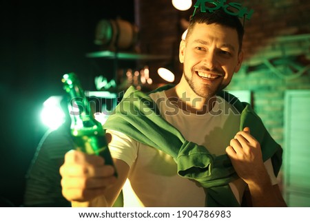 Man with beer celebrating St Patrick's day in pub
