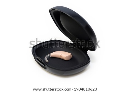 Micro hearing aid device. Hearing aid in black box on white background. Modern digital technology for deaf people.