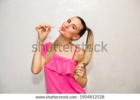 Portrait of a young girl eating gum. White background.