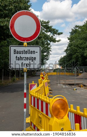 View of a construction site for a new street with traffic signs with the German text "construction sites vehicles free" and a safety fence in Leipzig, 
