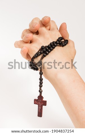 hands of a woman holding a rosary and praying. White background. Royalty-Free Stock Photo #1904837254