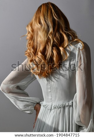 Honey blonde hair model wearing delicate tulle dress. Curly hair close up.   Royalty-Free Stock Photo #1904847715