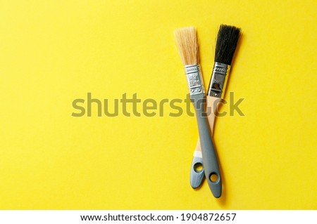 Color of the Year 2021. Gray Brushes on Yellow Background. Concept Repair