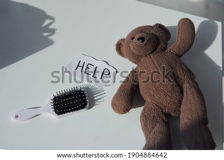 Teddy bear toy lying down on the table. Conception of domestic violence.