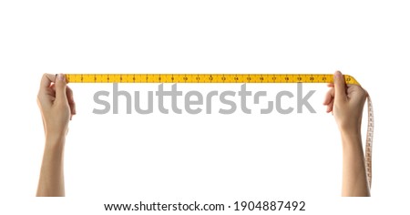 Woman holding yellow measuring tape on white background, closeup Royalty-Free Stock Photo #1904887492