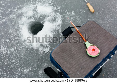 Close up ice fishing tackle and equipment near the ice hole. Winter fishing concept. Ice fishing. High quality photo