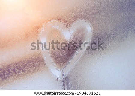 Heart on misted glass. Heart on a window background. Heart symbol of love drawn on the glass