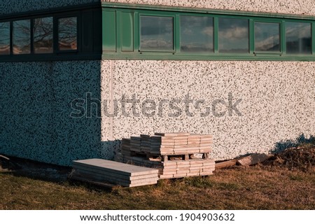 Concrete planks stacked on the lawn in front of an industrial warehouse (Pesaro, Italy, Europe)