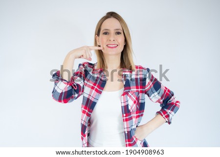 Picture of beautiful woman pointing to teeth over white background.