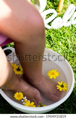 girl in garden with her feet in water and flowers