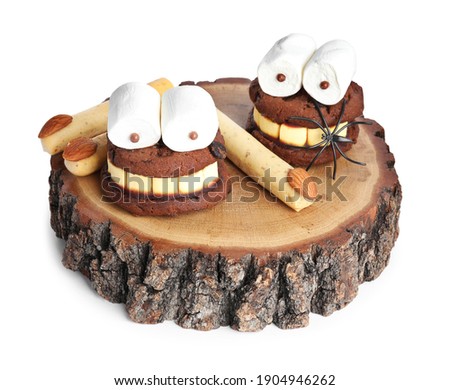 Delicious desserts decorated as monsters on white background. Halloween treat