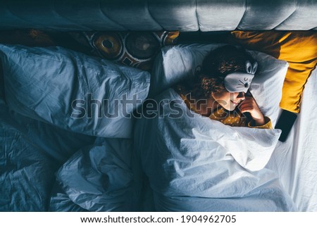 Woman sleeping with a sleep mask on her eyes.  Royalty-Free Stock Photo #1904962705