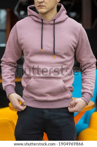 Handsome attractive European muscular man in purple hoodie
