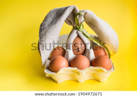 Easter eggs funny picture. Brown eggs with drawn faces wrapped in cotton serviette