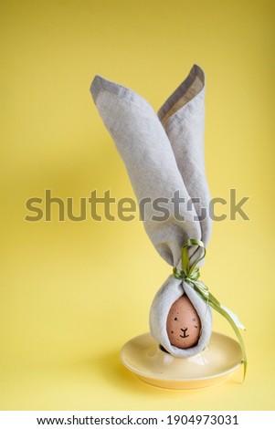 Easter eggs funny picture. Brown eggs with drawn faces wrapped in cotton serviette