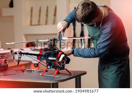 Photo of young male engineer or technician repair drone