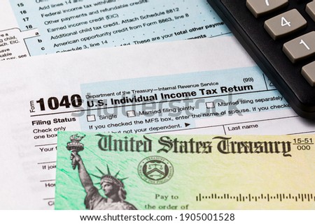 1040 individual income tax return form and tax refund check. Concept of filing taxes, taxable income and tax information. Royalty-Free Stock Photo #1905001528