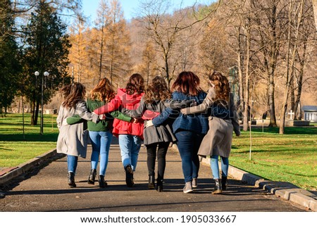 Young group of girls walking in autumn park, autumn clothes and autumn walk. Graduation from high school 2021.