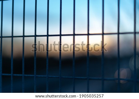 Colourful sunset through metal fence