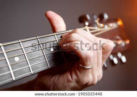 Fingers on the guitar fretboard.