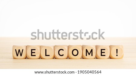 WELCOME word on wooden blocks on wood table. Copy space. White background