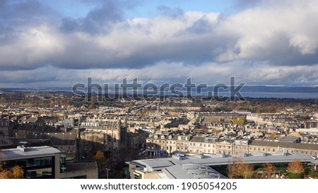 Aerial view of historical Edinburgh cityscape rooftop in morning with clouds in blue sky background. Viewed from Calton Hill. No people.