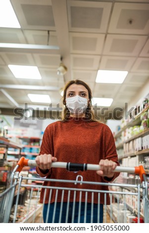 Beautiful woman wearing protective disposable mask shopping in mall. New normal concept during pandemic corona,covid19.