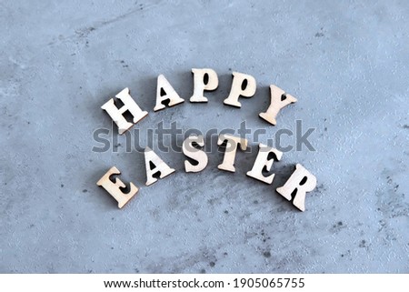 Inscription in English from wooden letters - Happy Easter. The background is blue. Holiday postcard