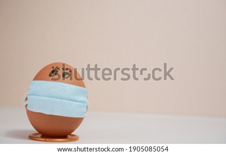 Eggs put on face mask - quarantine concept during Easter. Easter eggs in a medical mask. Self-isolation concept.