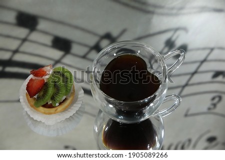 Valentine's day romantic breakfast background.Drink in the shape of a heart in a glass cup on a mirror table with reflection of notes and cake with strawberries and kiwi