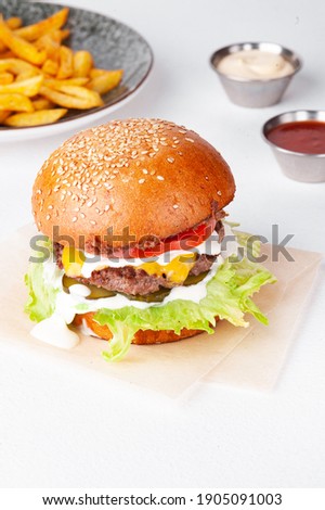 Single tasty burger with french fries and sauces