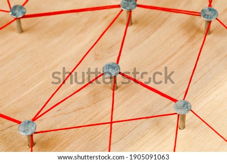 threads and nails on a wooden board