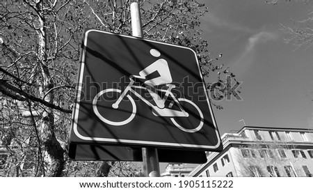 Squared road sign indicating a bicycle lane with stylized bicycle on blue background, in a sunny day