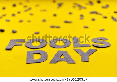 Image caption Fools' Day of paper letters grey on a yellow background close-up with confetti on the top edge. High quality photo